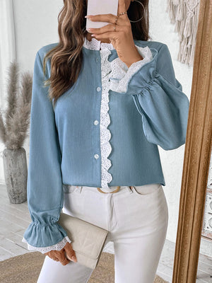 Light blue button-up blouse with white lace trim on collar and cuffs, long sleeves.