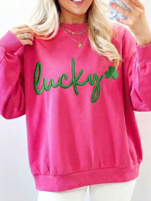 Pink crew neck sweatshirt with green embroidered lucky clover graphic