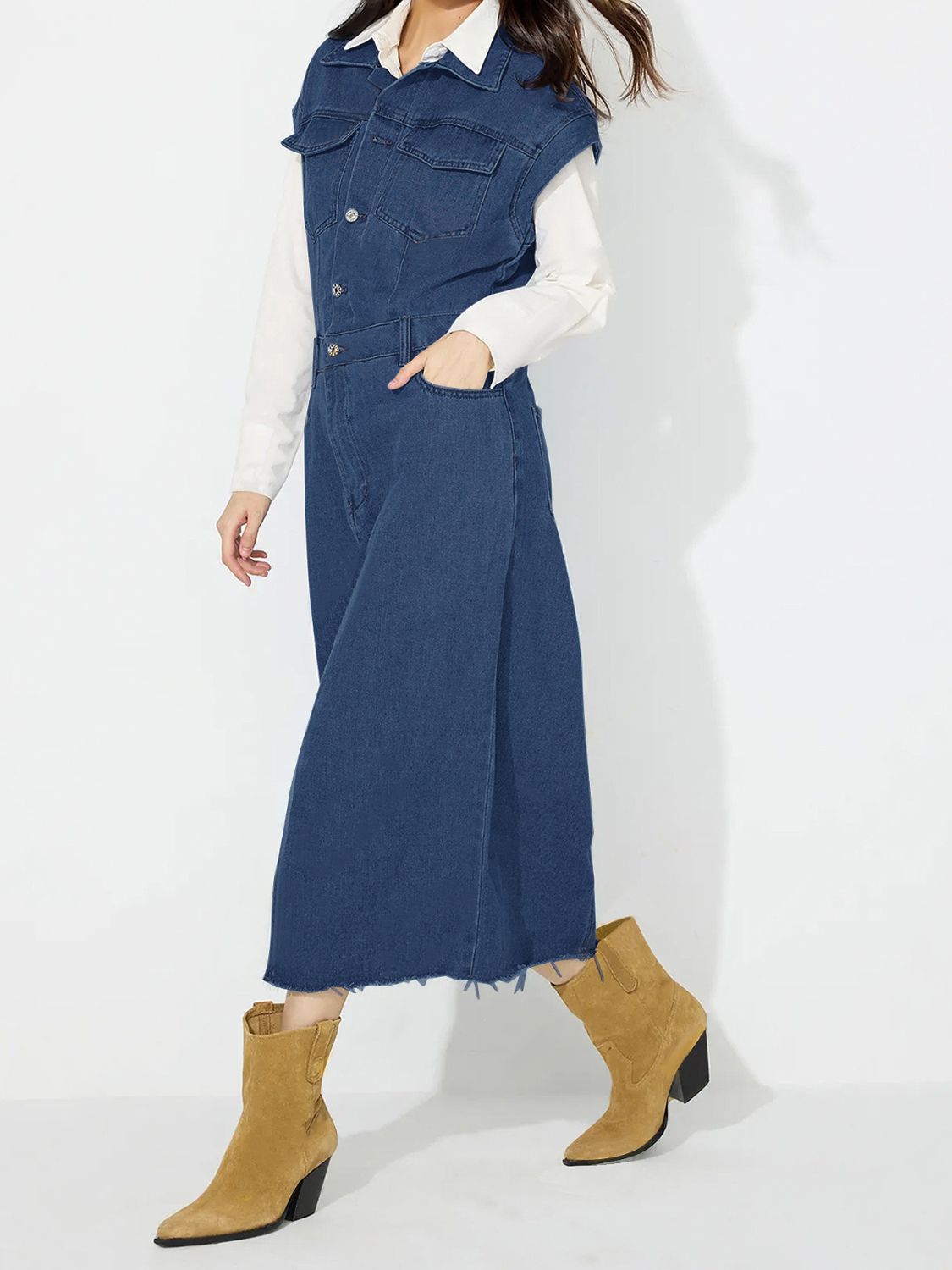 Sleeveless dark wash denim midi dress with button front, pockets, and frayed hem.