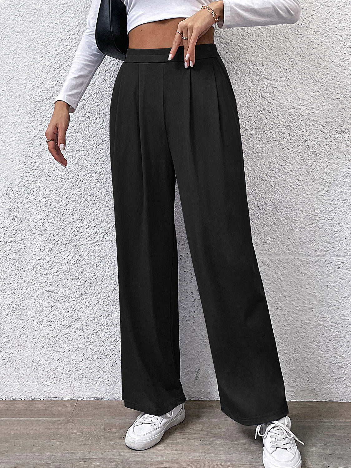 Black wide leg trousers with front pleats and a high waist.
