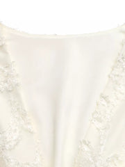 Chic textured mini dress in apricot with ruched detail and lace trim.