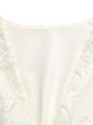 Chic textured mini dress in apricot with ruched detail and lace trim.