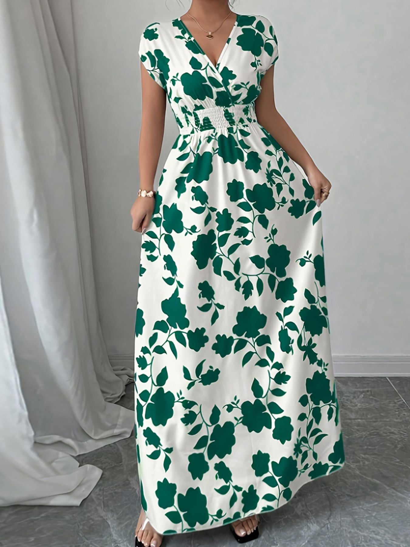 Floral surplice maxi dress in white with green floral print, cap sleeves, and smocked waist.