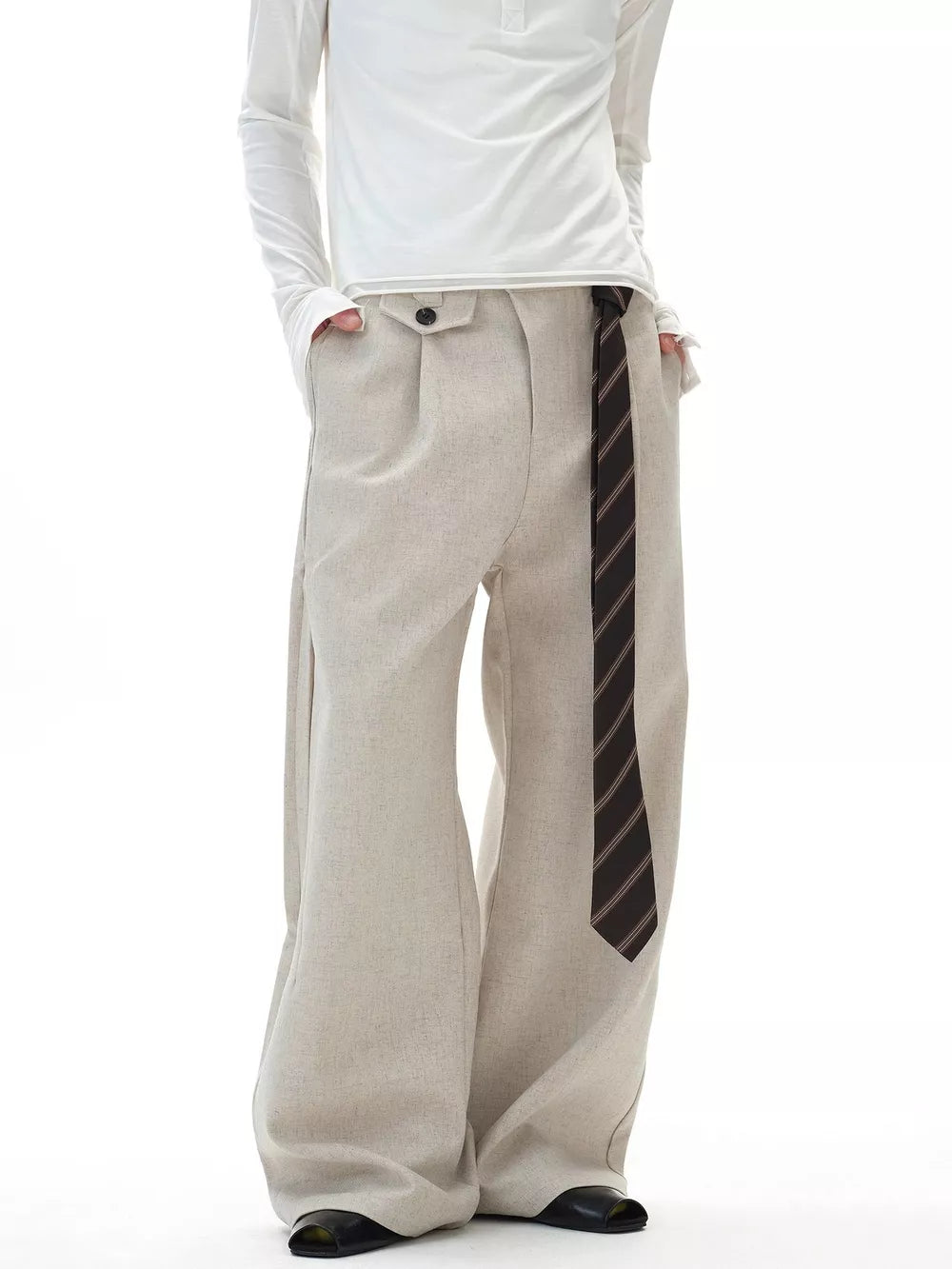Men's beige wide-leg cargo pants with button closure and a striped tie accent.