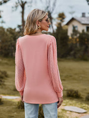 Pink Swiss dot sleeve V-neck top with textured sheer sleeves.