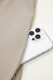 Beige ribbed knit mini dress detail with a white smartphone.