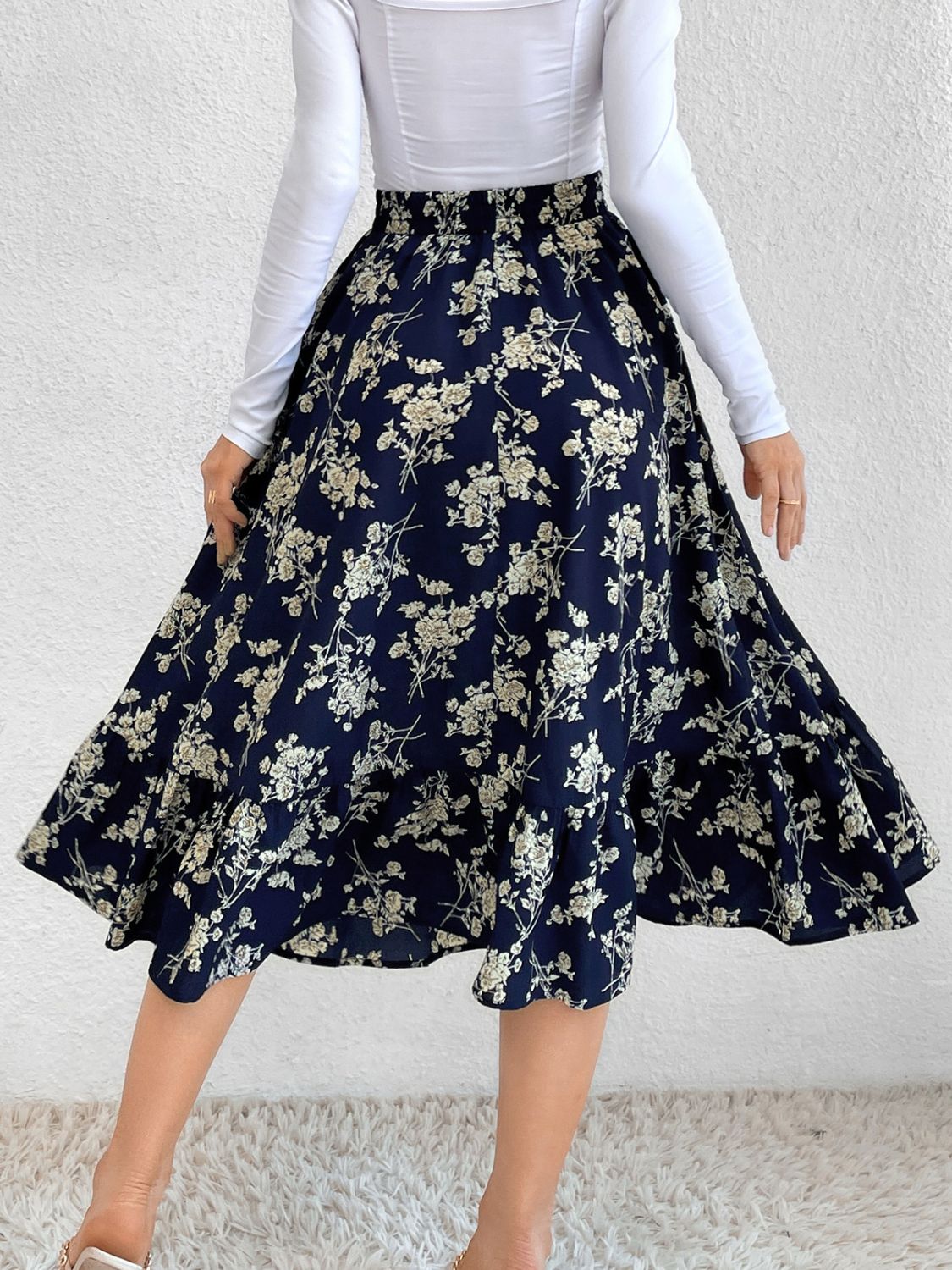 Navy floral print midi skirt with tiered hem and ruffled detail.