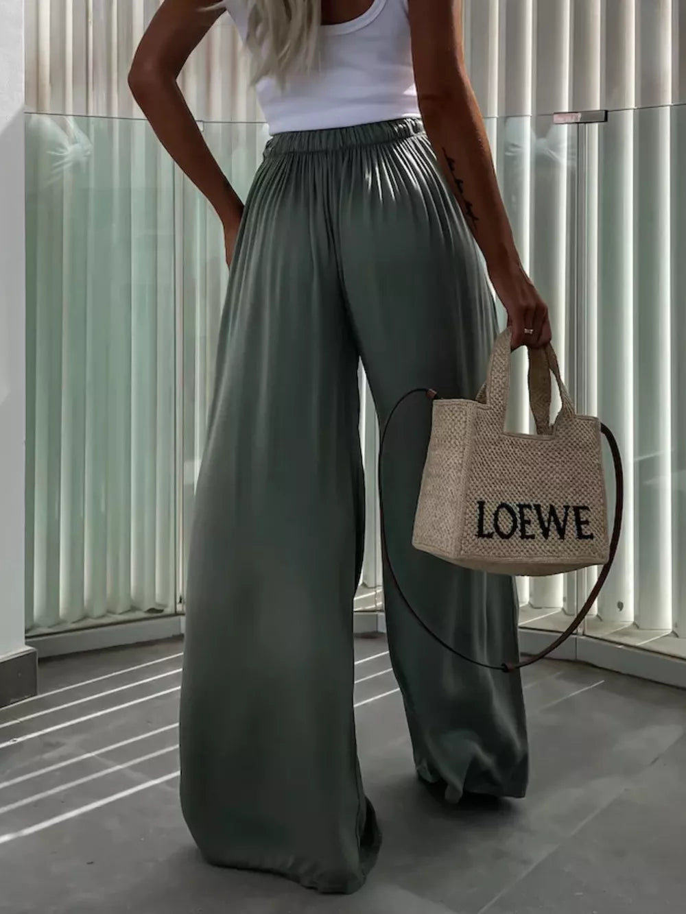 Green maternity pants with paperbag waist and wide legs, styled with a white tank and straw bag.