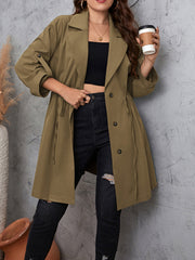 Gathered waistline trench coat with roll-tab sleeves and tie detail in a neutral tone.