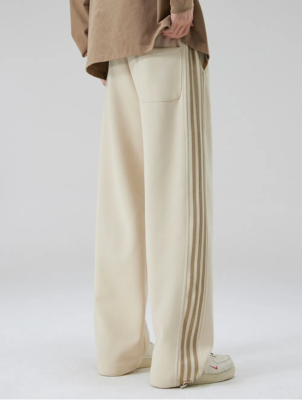 Khaki cotton sweatpants with wide legs and striped side detail.