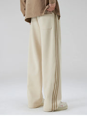 Khaki cotton sweatpants with wide legs and striped side detail.