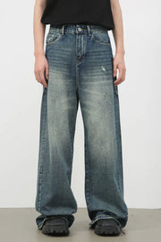 Distressed denim wide leg jeans in medium wash with a relaxed fit.