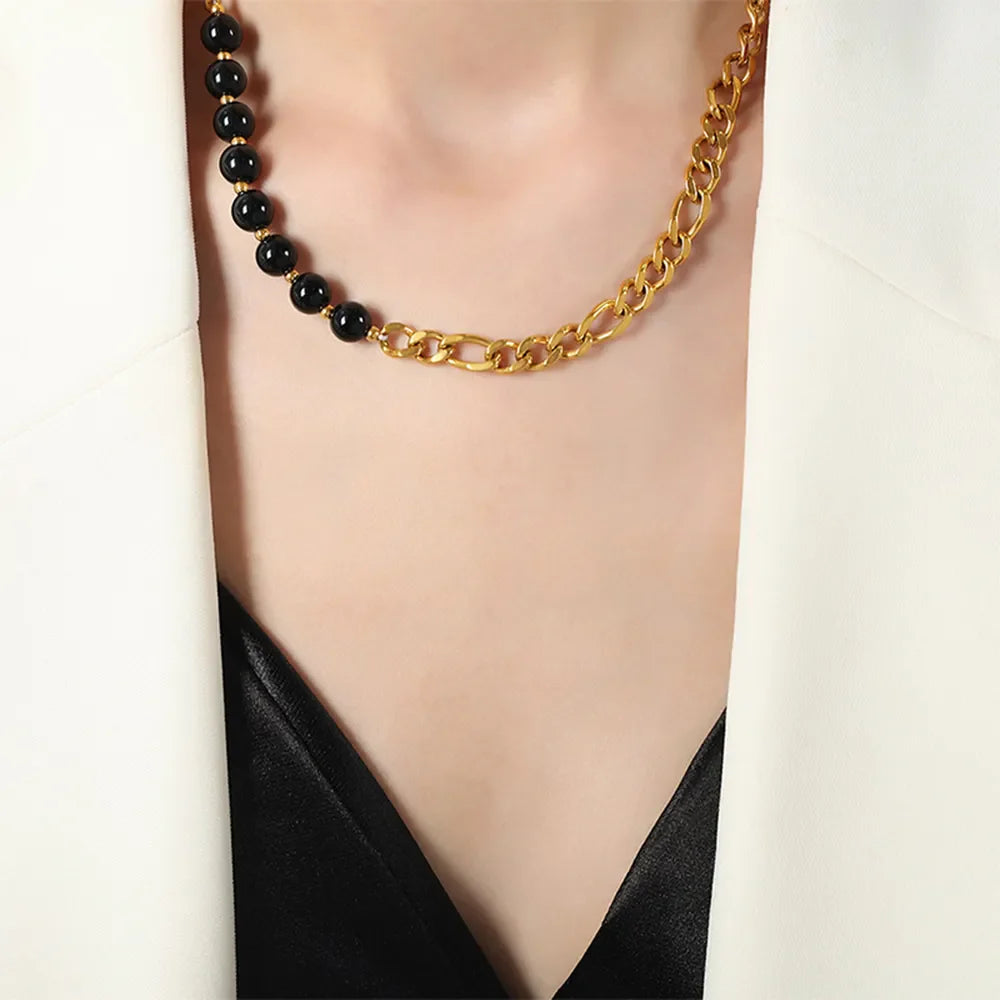 Gold asymmetrical necklace with black beads and figaro chain detail