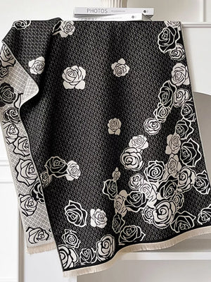 Black scarf with white rose pattern and diamond texture, fringed edges.