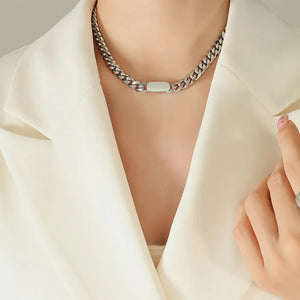 Silver Cuban link chain necklace with a smooth oval pendant detail.