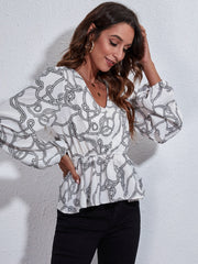 White peplum blouse with rope print, V-neck, gathered waist, and balloon sleeves.
