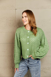 Green acrylic cropped cardigan with bubble sleeves and button front.