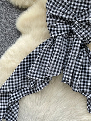 Black and white gingham cami top with twisted knot detail and asymmetrical hem.