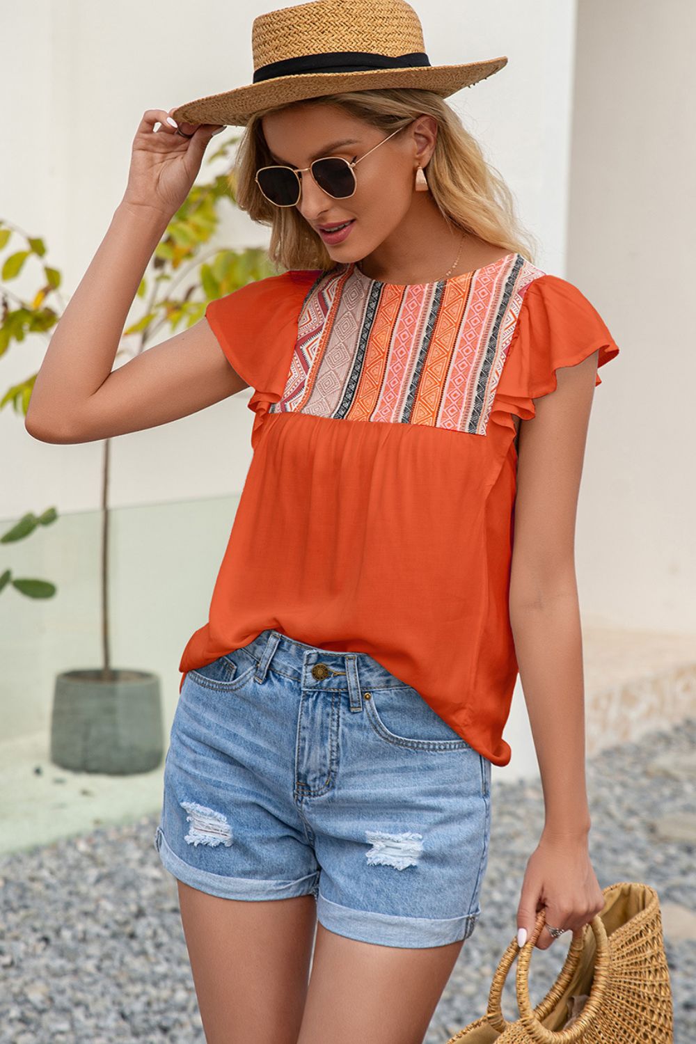 Orange blouse with embroidered yoke and ruffle sleeves.
