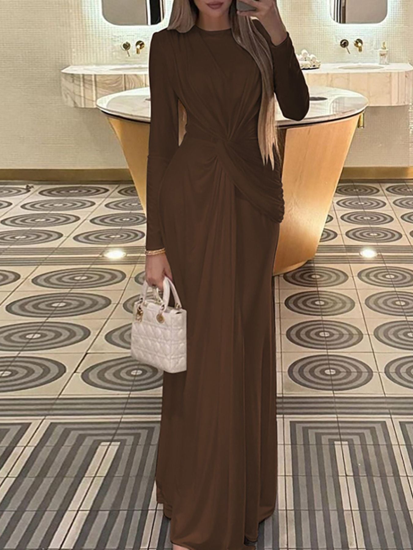 Brown ruched knot front maxi dress with long sleeves and a crew neckline.