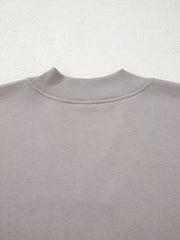 Gray sweatshirt with ribbed mock neck detail and embroidered Aztec pattern.