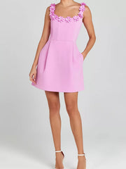 Pink floral embellished mini dress with pockets and square neckline.