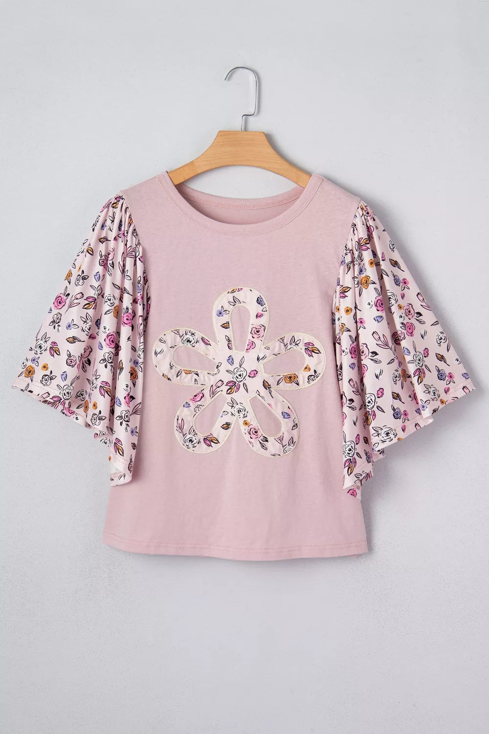 Maternity crew neck shirt in pink with floral patchwork sleeves and a large floral applique on the front.
