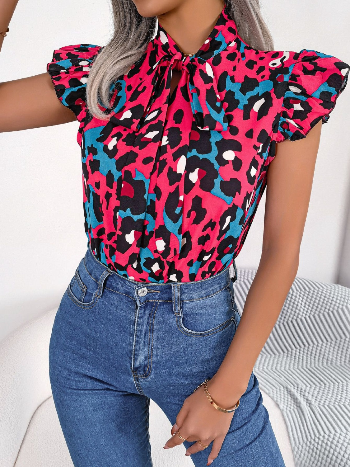 Hot pink leopard print blouse with ruffled sleeves and pussybow tie neckline.