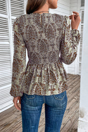 Brown damask print peplum blouse with smocking and long sleeves.