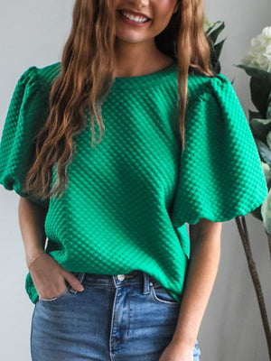Diamond quilted puff sleeve top in turquoise with a round neckline.