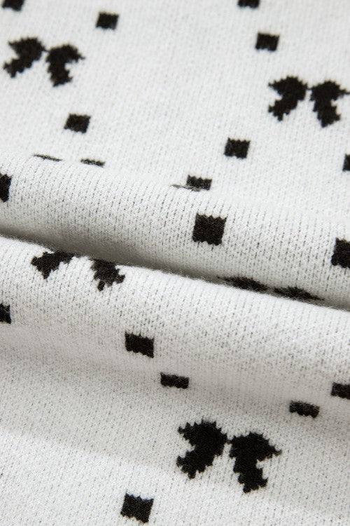 White knit sweater with a black diamond bow pattern