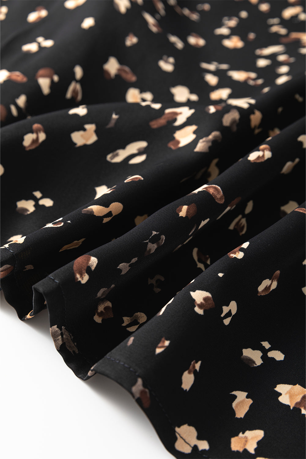 Black high-neck blouse with abstract print and draped fabric detail