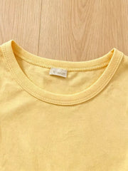 Light yellow cotton baby top with crew neck and tag detail