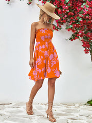 Orange floral smocked bandeau mini dress with drawstring waist and A-line skirt.