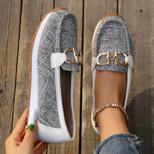 Grey textured round toe slip-on loafers with gold buckle detail and white trim.
