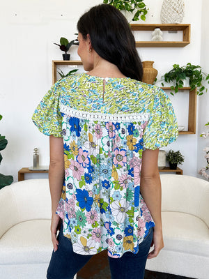 Floral patchwork blouse with puff sleeves and crochet trim.