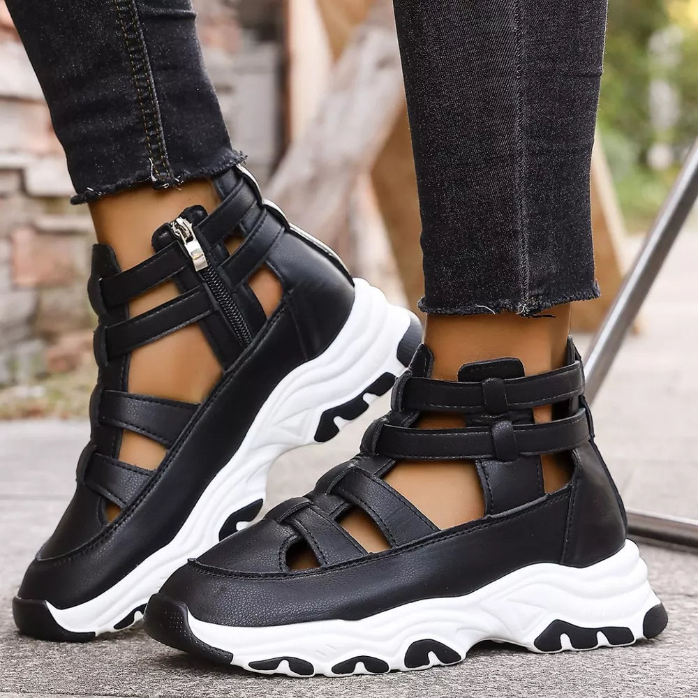 Black chunky cutout platform sneakers with ankle straps and zipper detail.