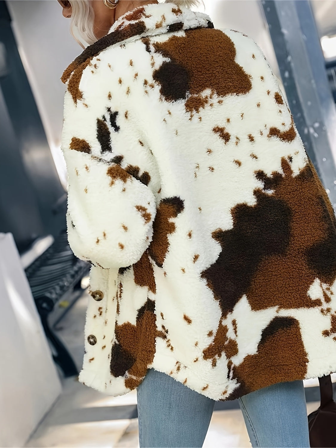 Cow print plush shacket in ivory with brown spots, featuring button closure and fuzzy texture.