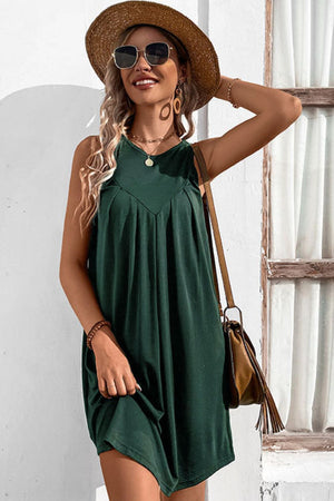 Forest green trapeze dress with V-neck yoke and pleats, sleeveless, casual style