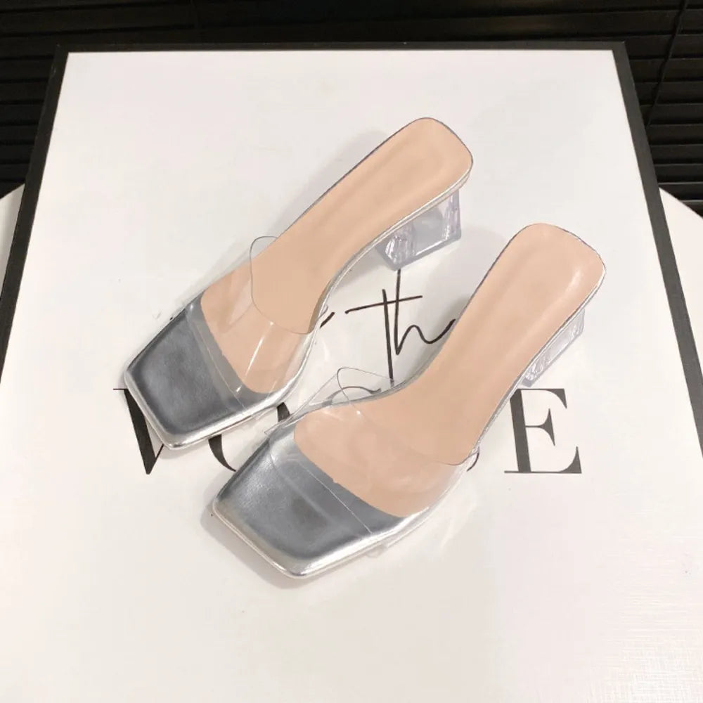 Silver square toe mules with clear lucite straps and block heels.