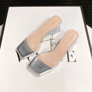 Silver square toe mules with clear lucite straps and block heels.