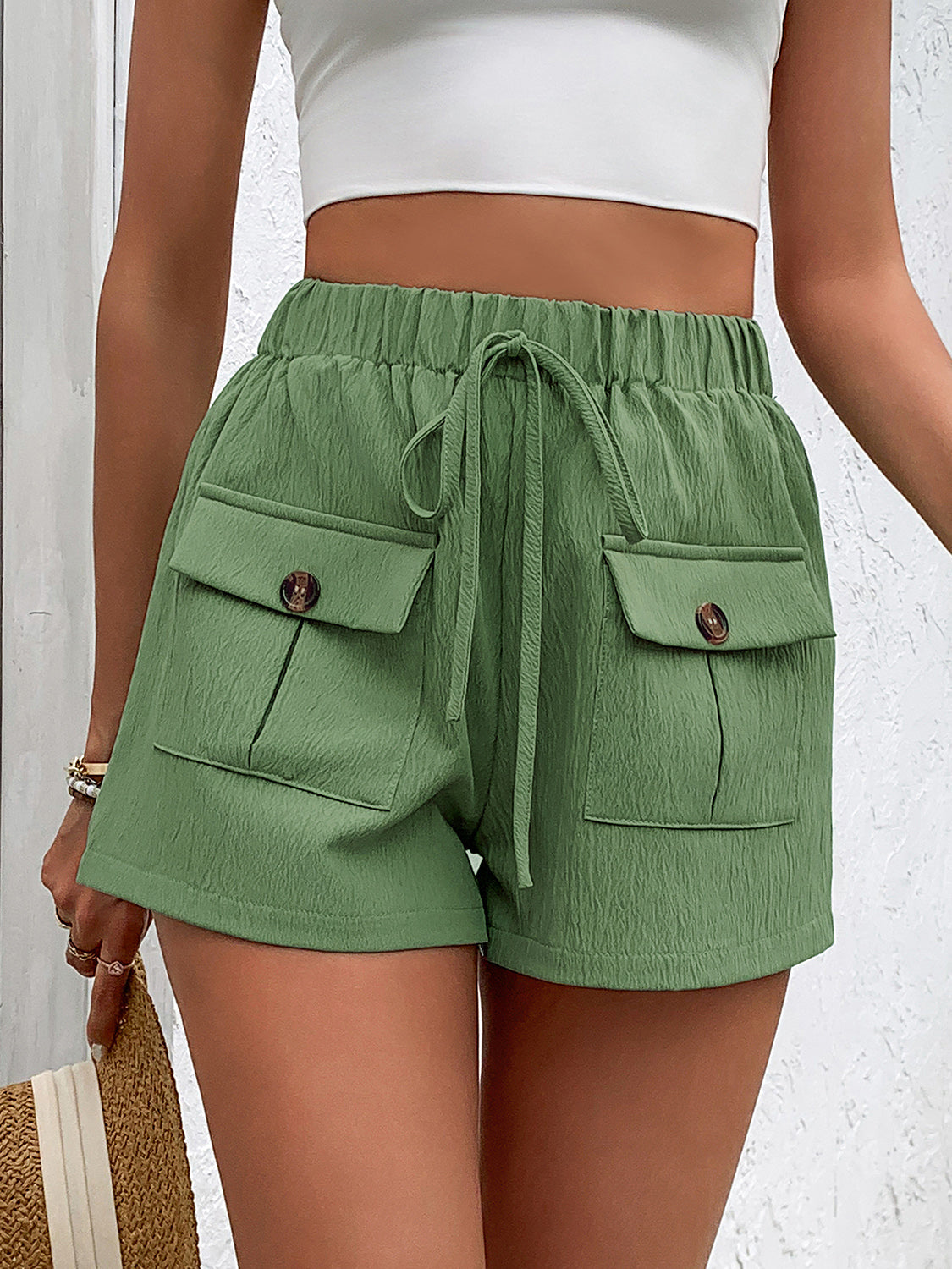Textured cargo shorts in gum leaf green with drawstring waist and decorative button pockets.