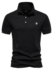 Black cotton polo shirt with embroidered crest detail and button placket.