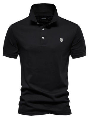 Black cotton polo shirt with embroidered crest detail and button placket.