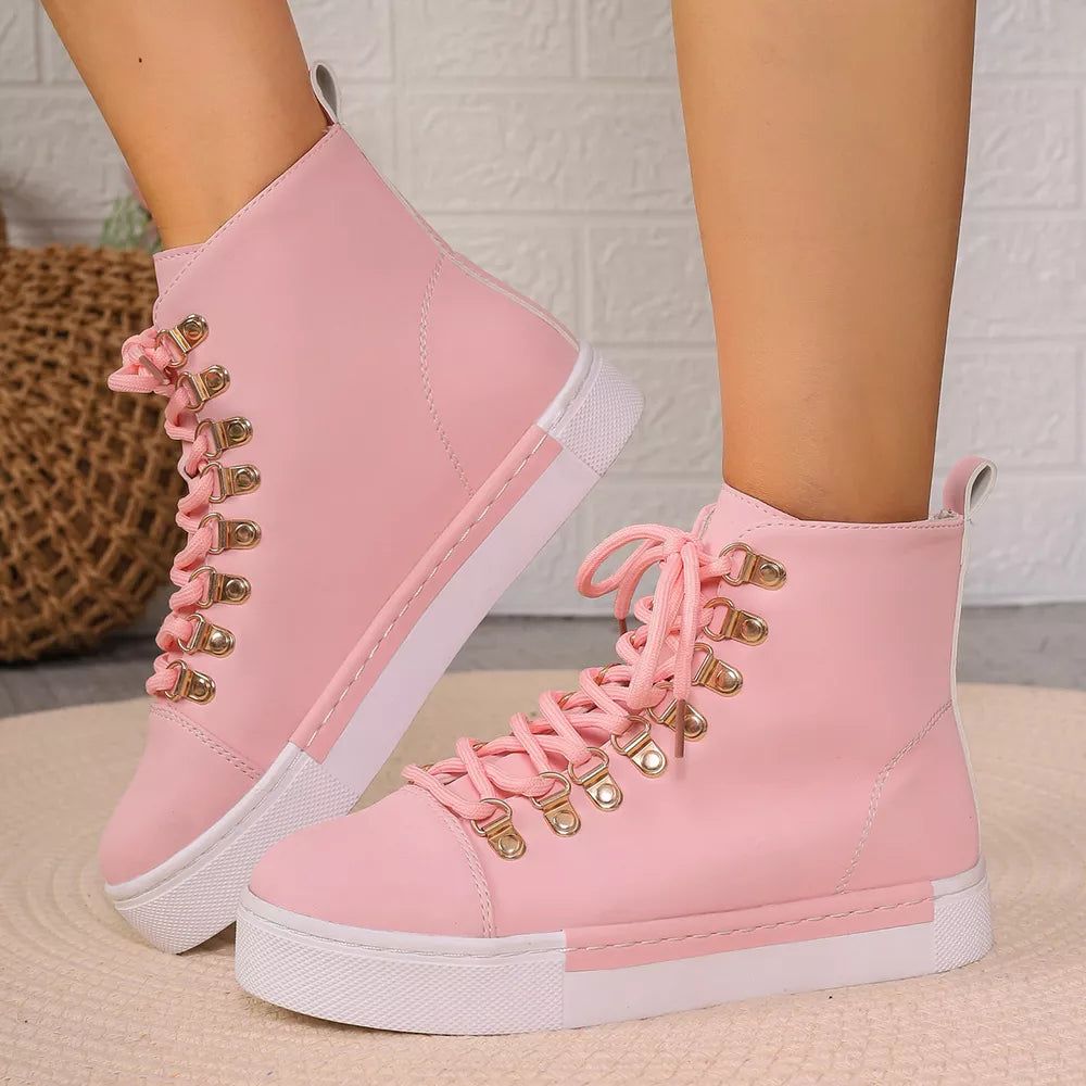Pink lace-up platform sneakers with gold d-ring eyelets and white soles.