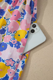 Floral mini dress with pockets in pink, yellow, and blue cotton blend fabric.