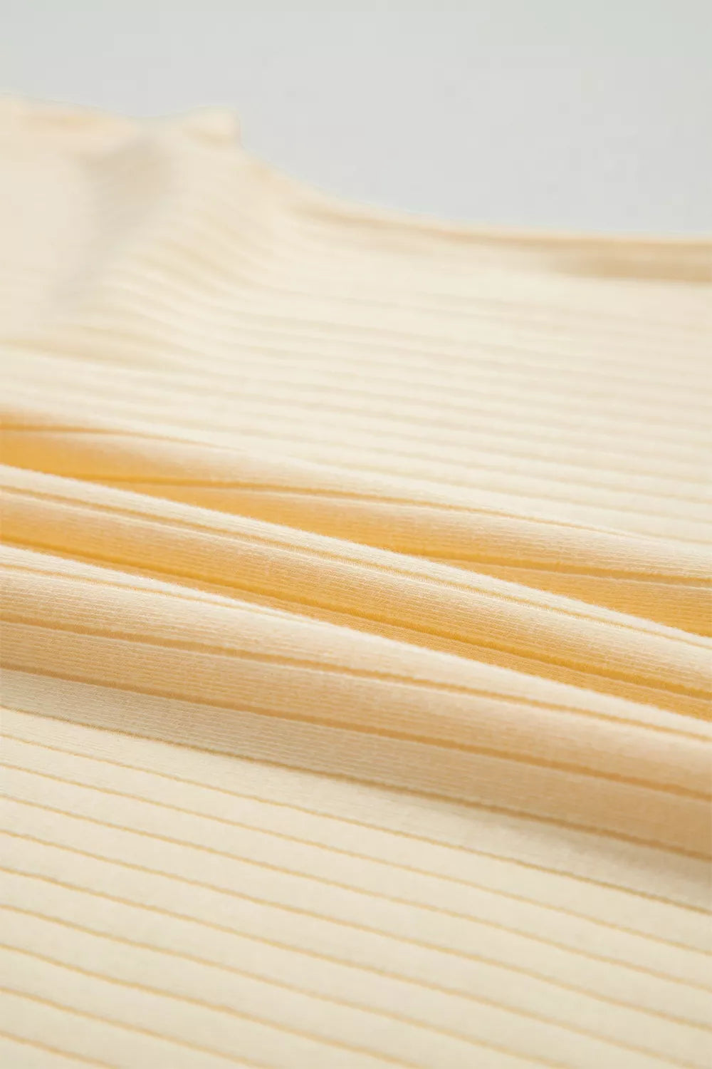 Ribbed cotton fabric in a pale yellow color, showing texture detail.
