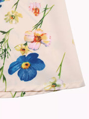 A-line maxi dress in cream with a blue, pink, and yellow floral print.