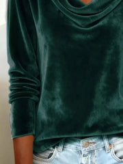 Green velvet t-shirt with cowl neck and long sleeves, styled with jeans.