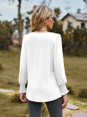 White long sleeve blouse with gathered yoke and smocked cuffs.